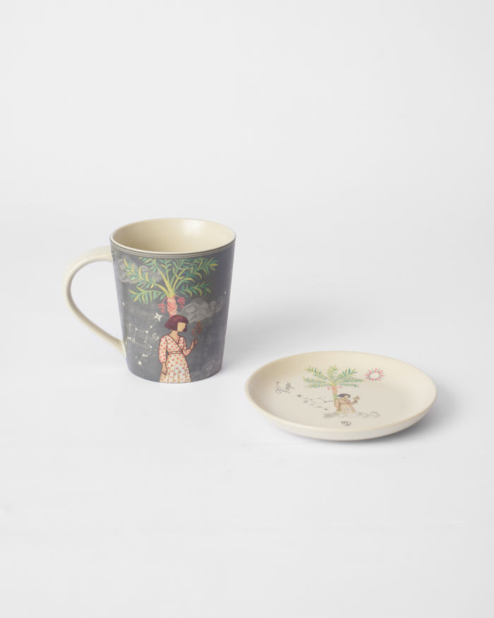Nico Virgo mug with a figure under a palm beside a matching tea plate.