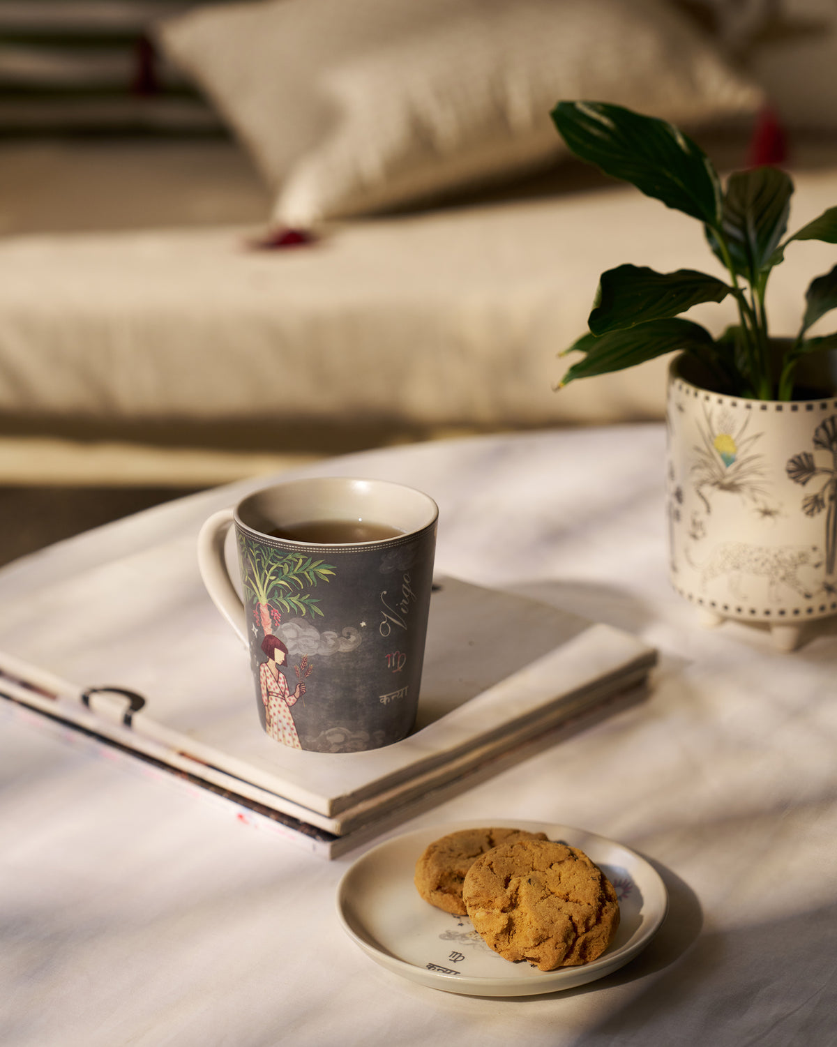 Nico Virgo mug and tea plate with cookies in a sunlit setting.
