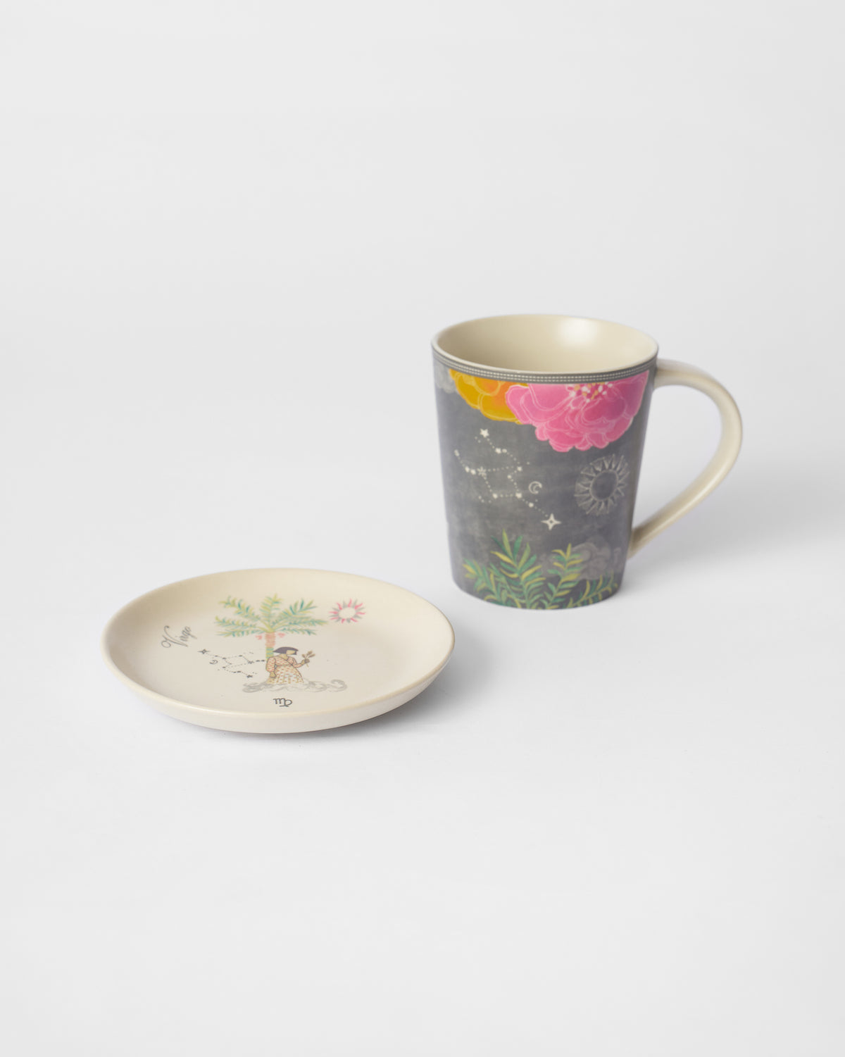 Nico Virgo tea plate with a palm tree motif beside the charcoal mug.