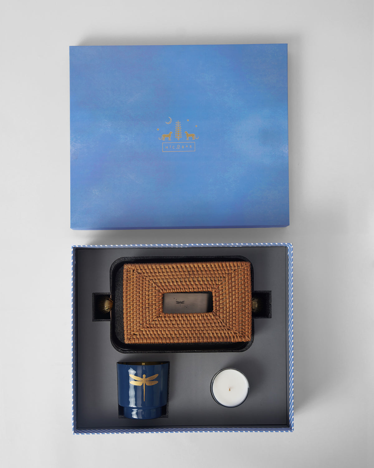 Open Laya gift box holding rattan tissue cover, navy cup and candle.