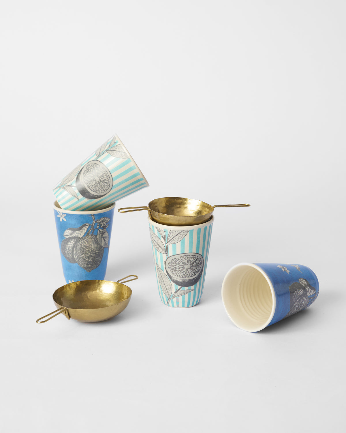 Neel blue citrus kulhars grouped with brass chai strainers for serving.
