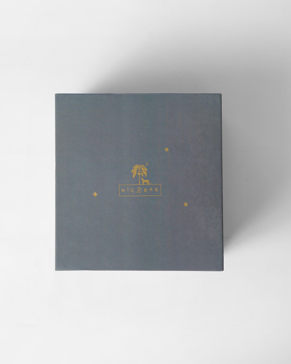 Top of the grey Tusker Gift Set box with a gold Nicobar logo.