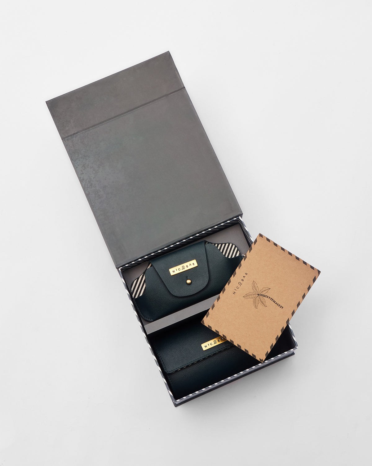 Tusker Gift Set leather pouch in an open grey box, with a kraft card resting on top.