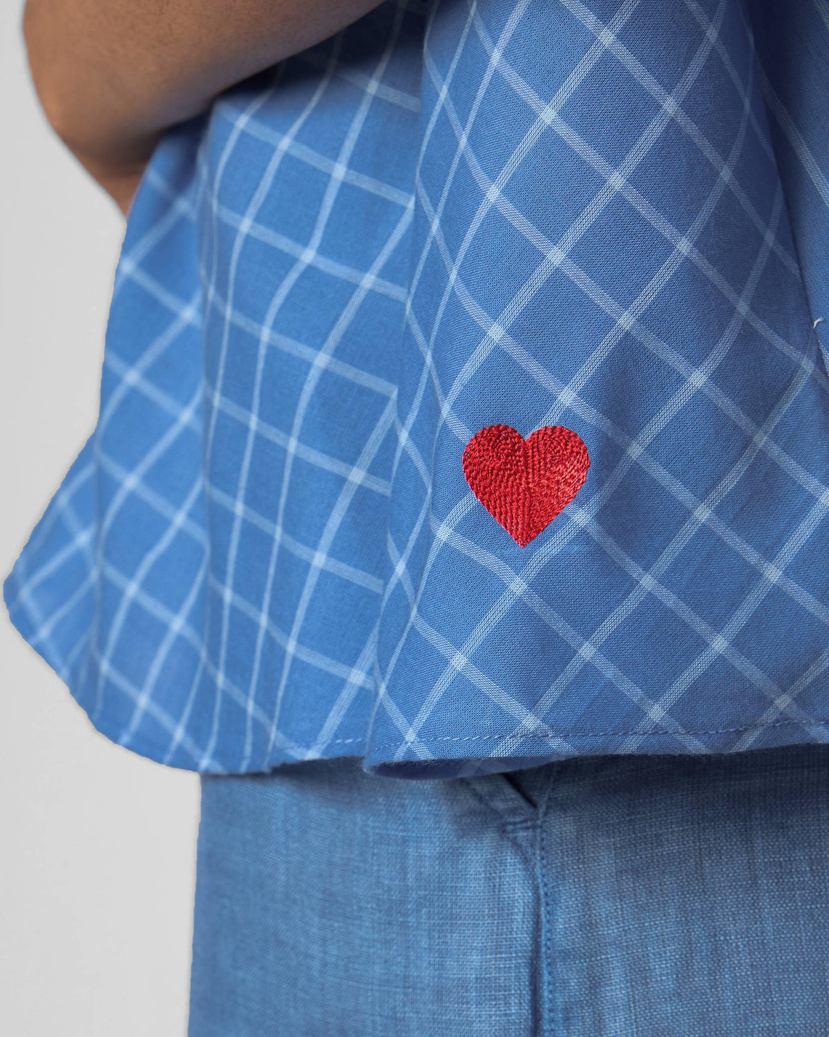 Close-up of a red heart on a riverside blue Rann shirt.