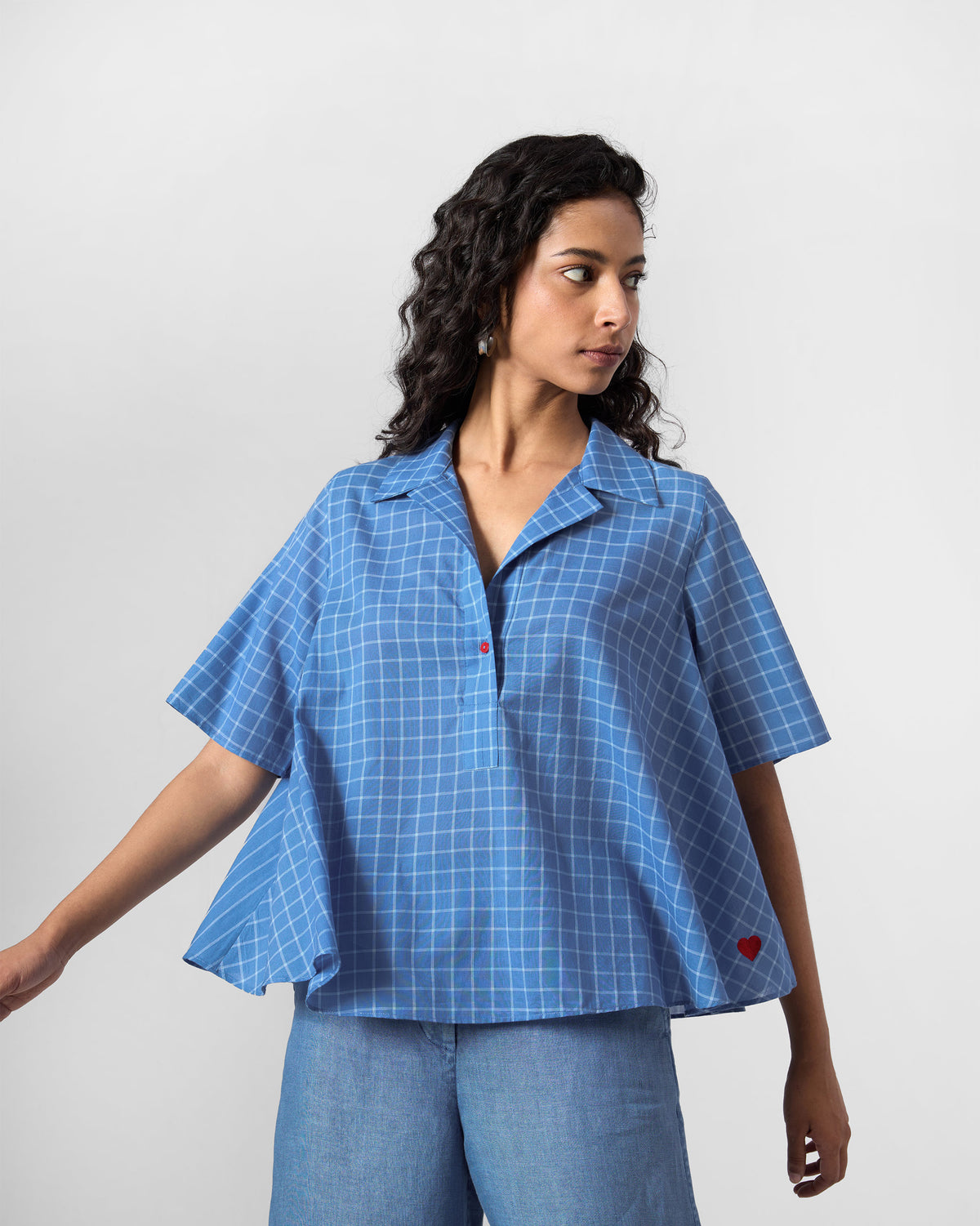 Person wearing a flared riverside blue checked Rann shirt.