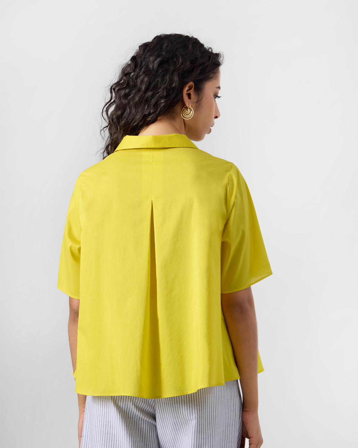 Back of a chartreuse Rann shirt with a deep inverted pleat.