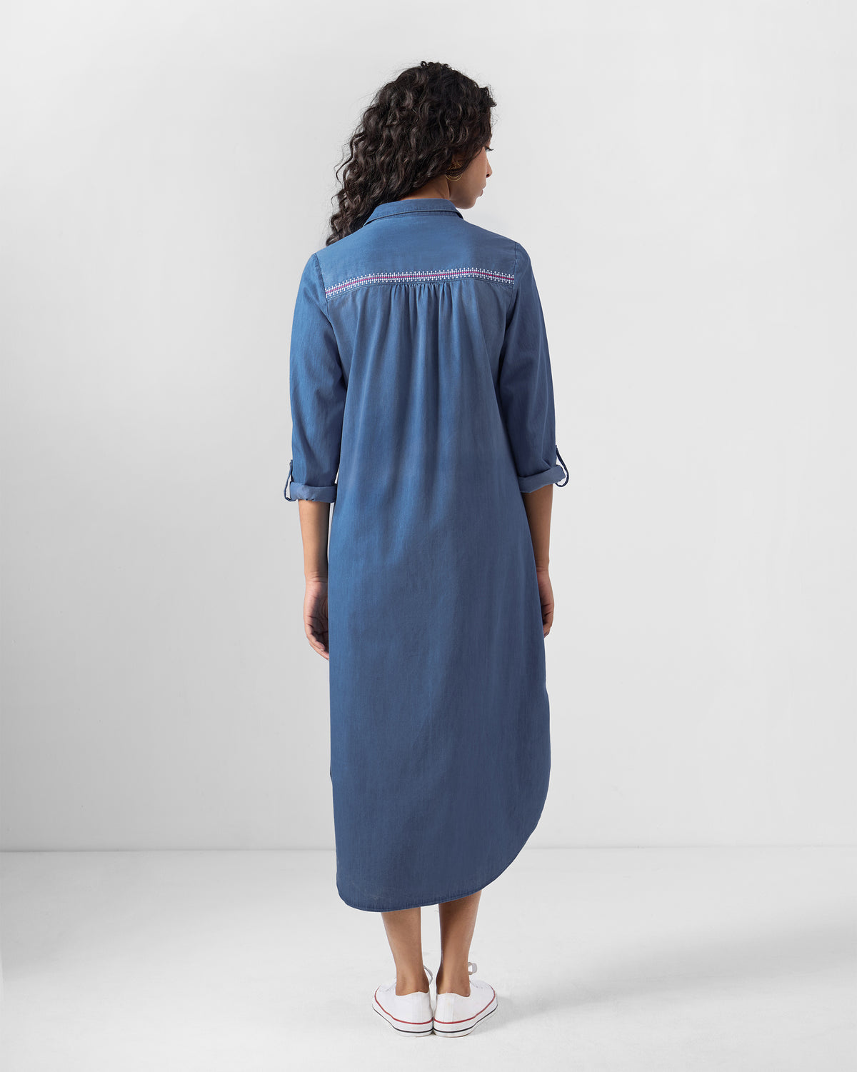 Back of a blue Pristine dress with pink embroidery on the yoke.