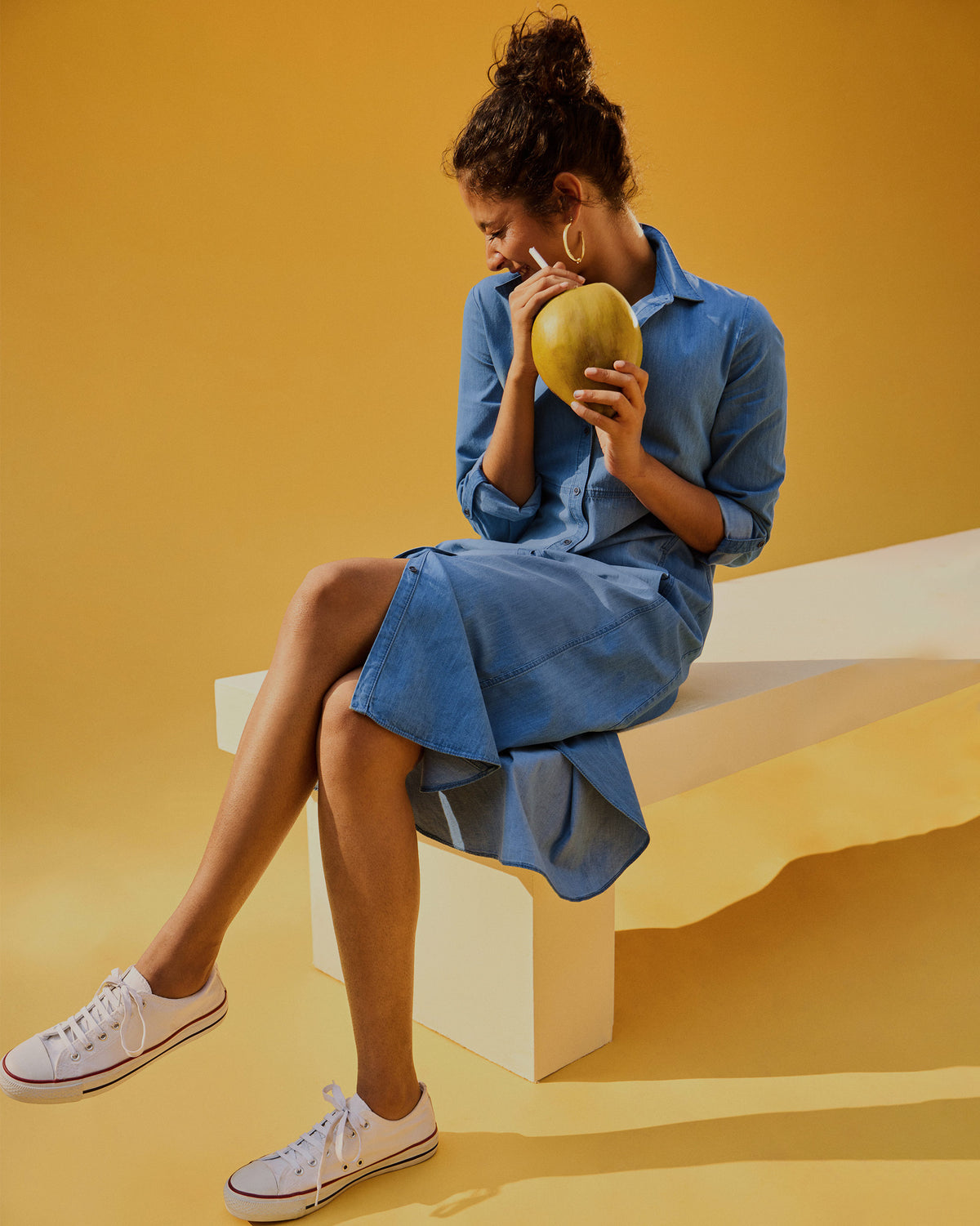 Person wearing a blue Pristine dress while seated.