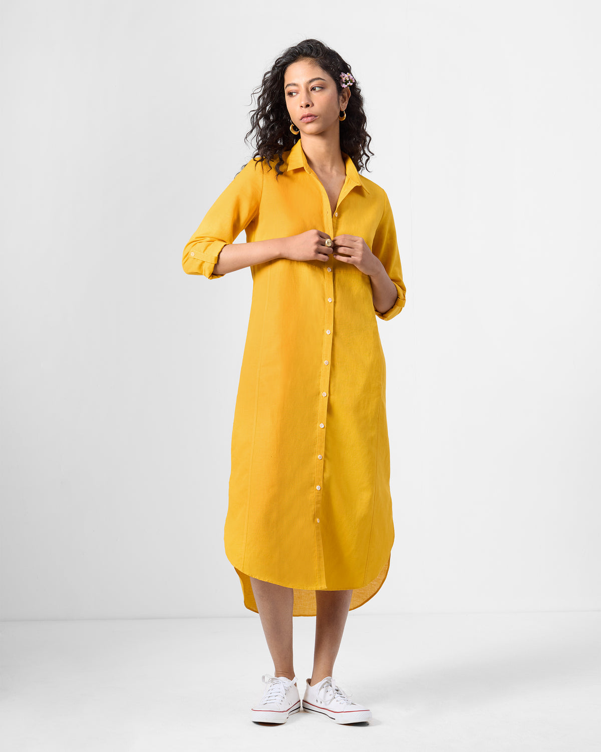 Person wearing an ochre Pristine dress with a full button placket and shirt collar.