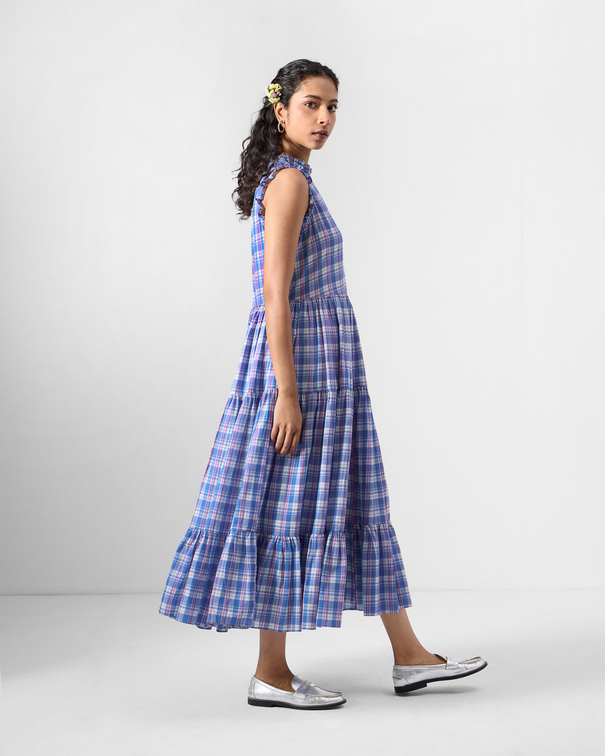 Side view of a blue checked Reah dress with tiered layers.