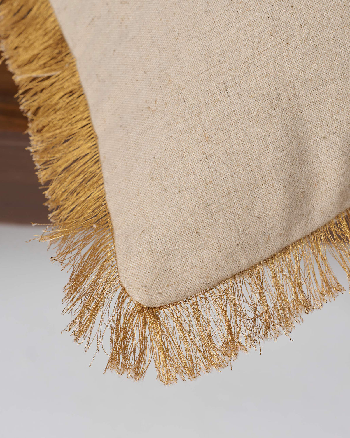 Close-up of the Gilded Palm Cushion Cover showing its gold fringed edge.