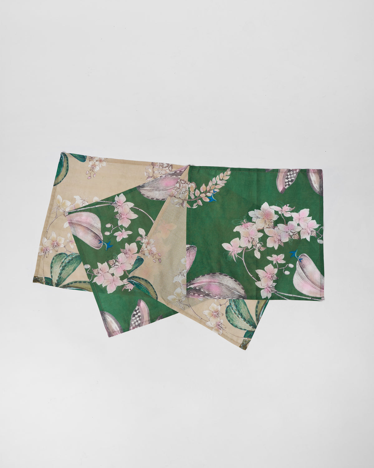Madhu Napkins laid flat, in cream and green with floral prints.