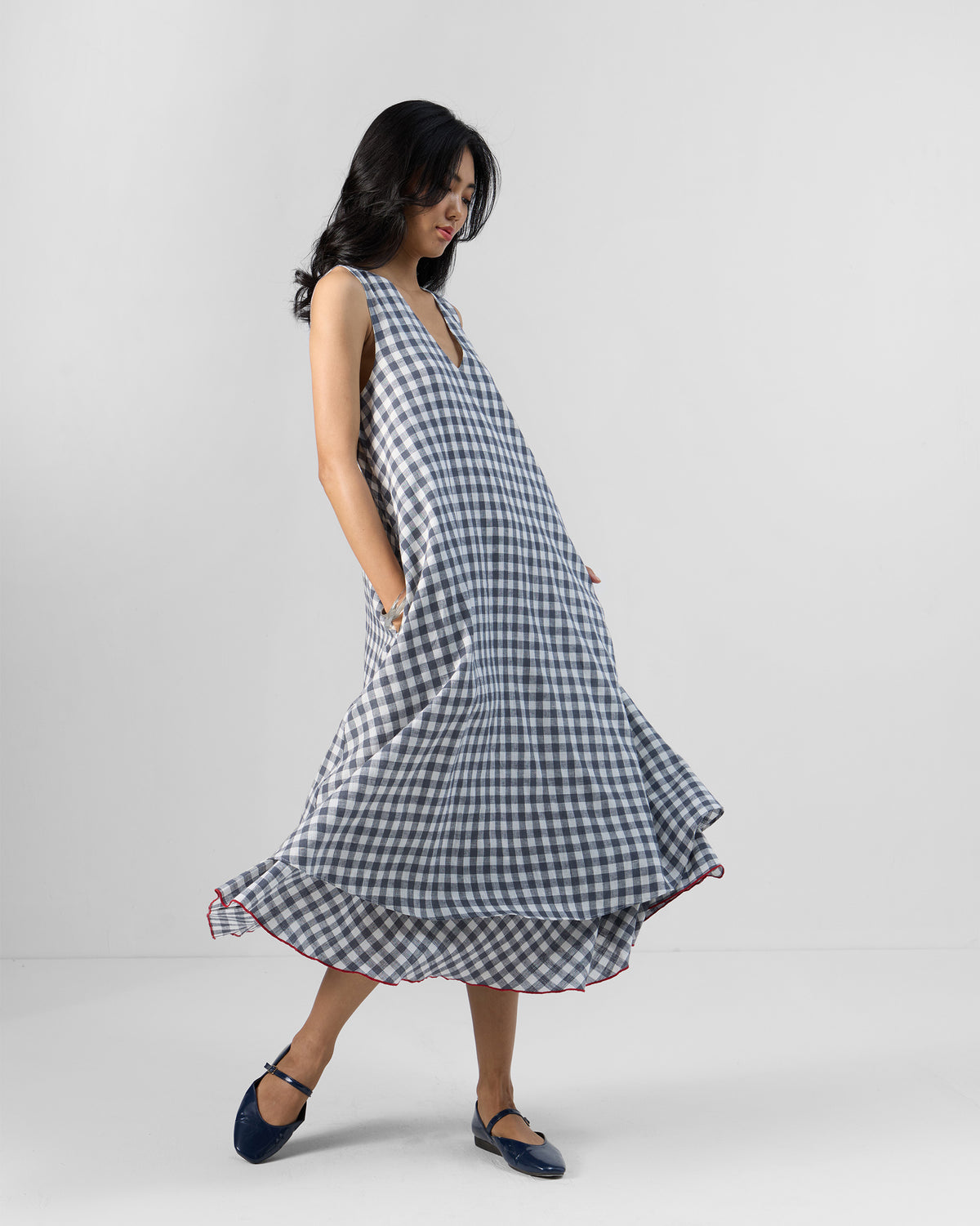 Side view of a grey and white check Ezra dress with side pockets.