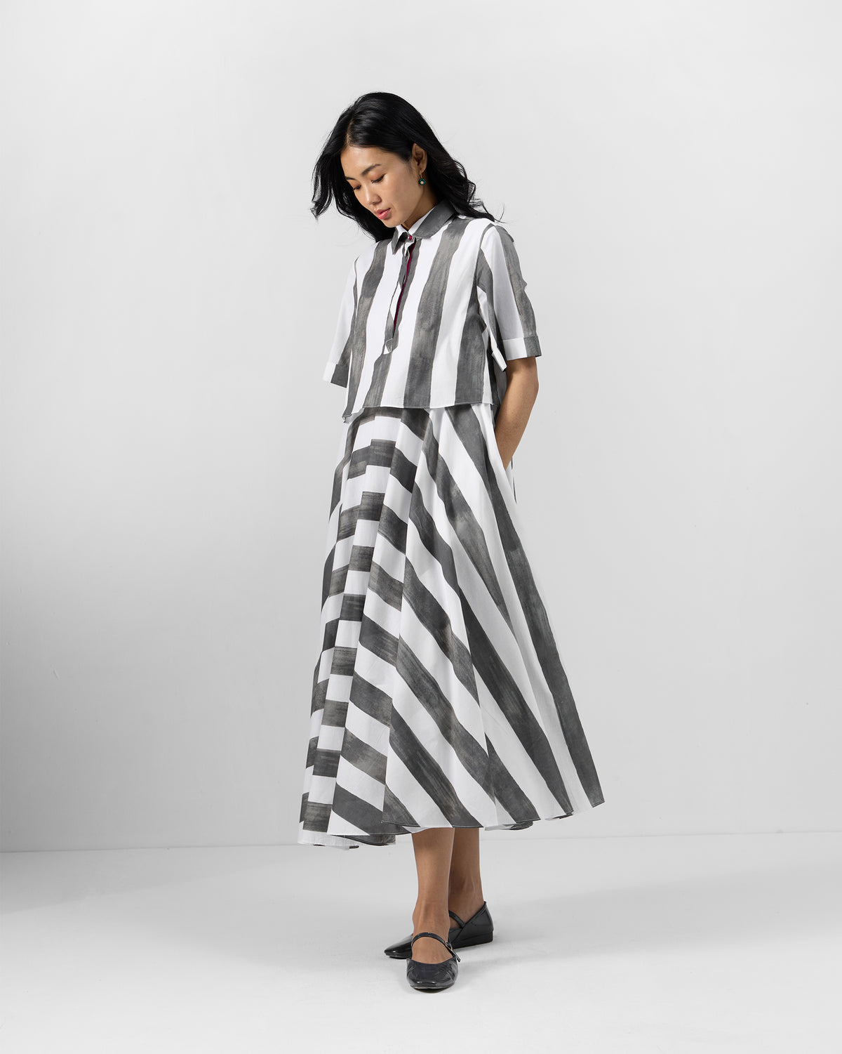 Person wearing a charcoal and white striped Kuro Dress with side pockets.
