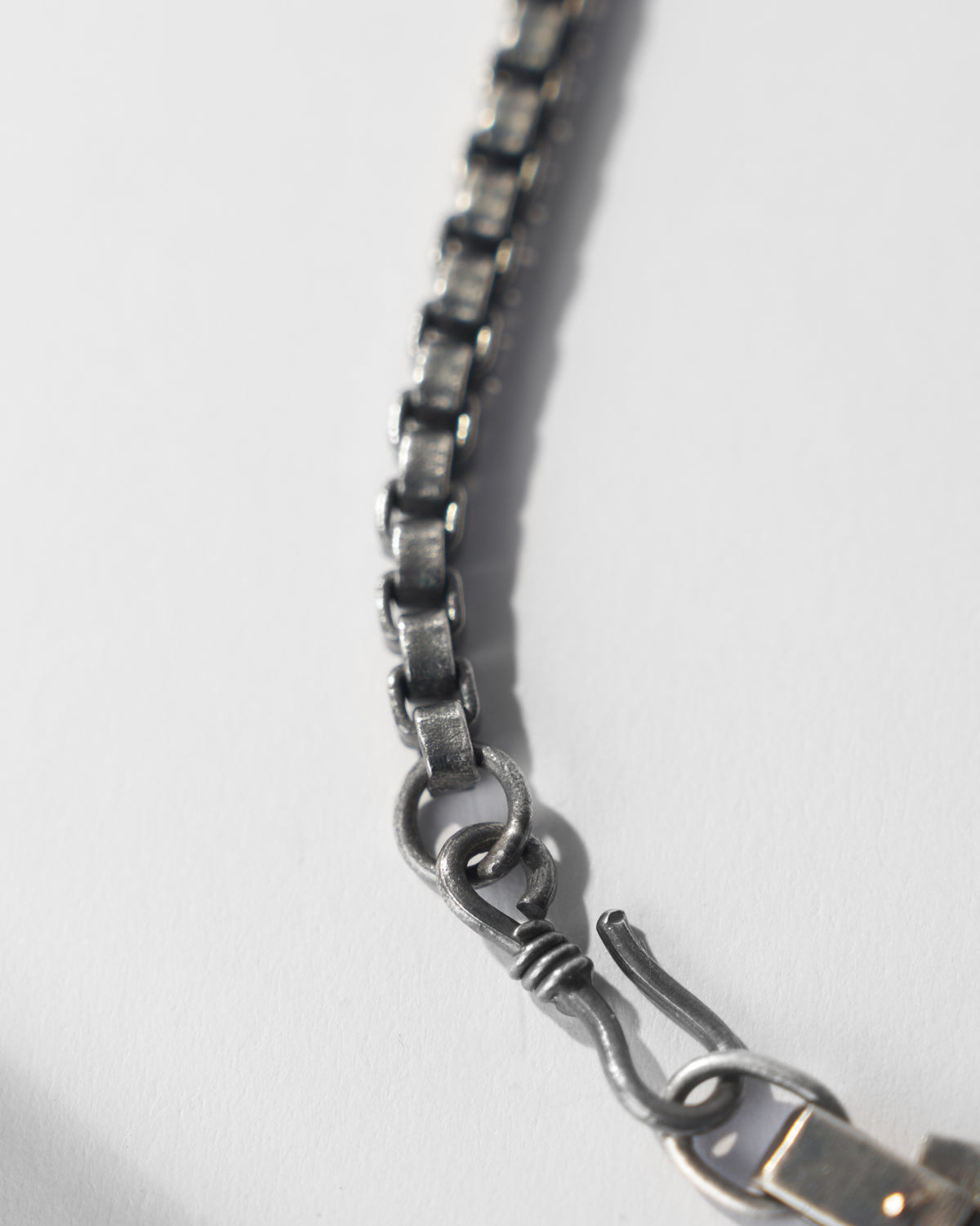 Close-up of the silver Taro box chain and S-hook clasp.