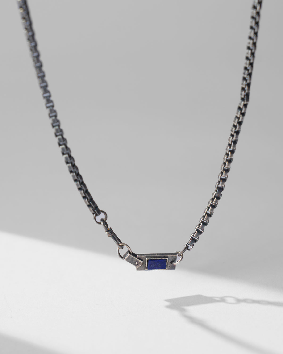 Silver Taro chain hanging to show the rectangular lapis accent.