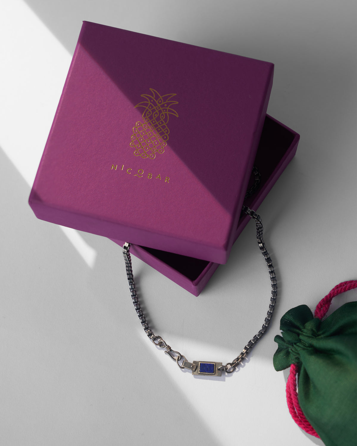 Silver Taro chain with magenta Nicobar gift box and green pouch.