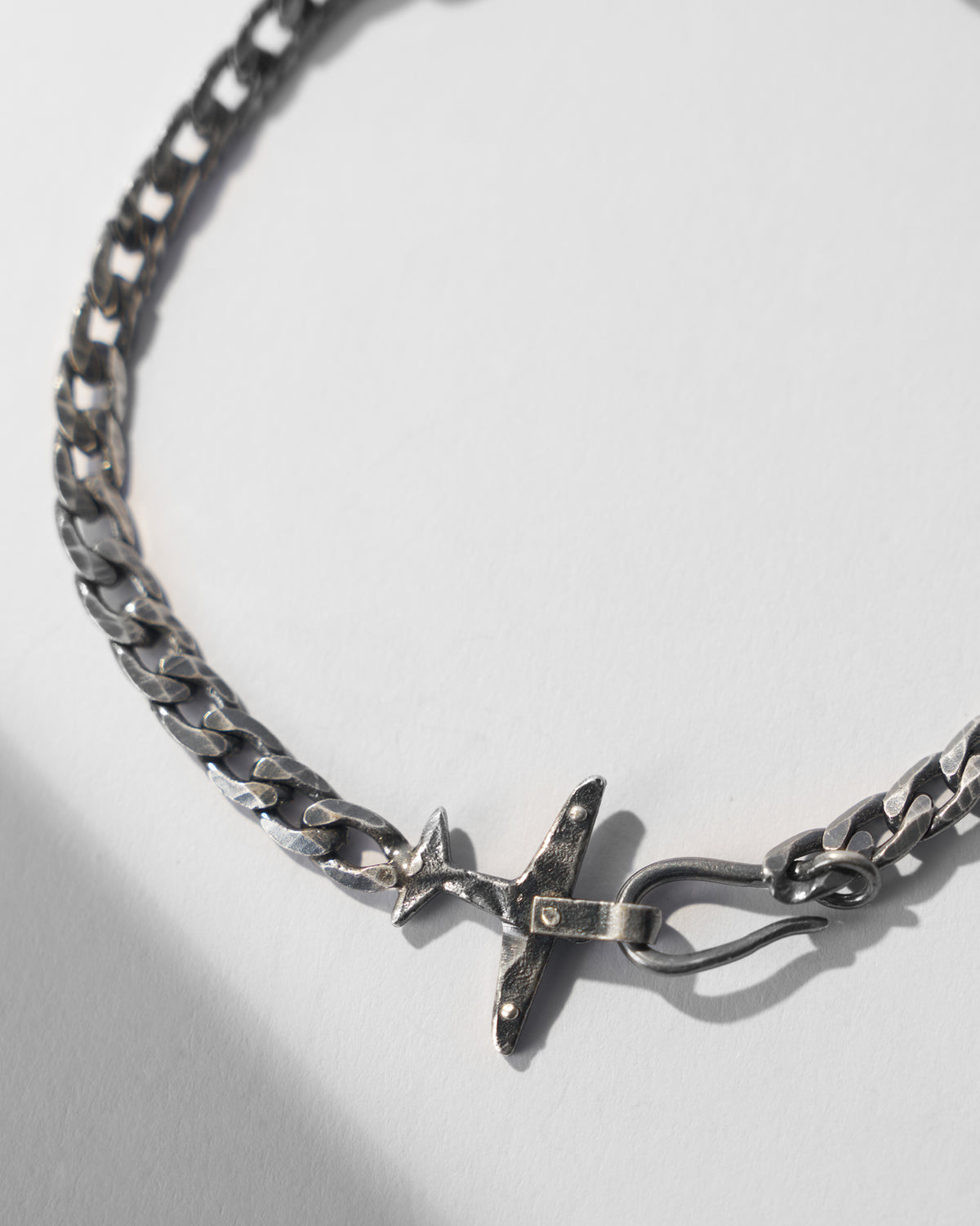Close-up of the airplane clasp on a silver flight bracelet.