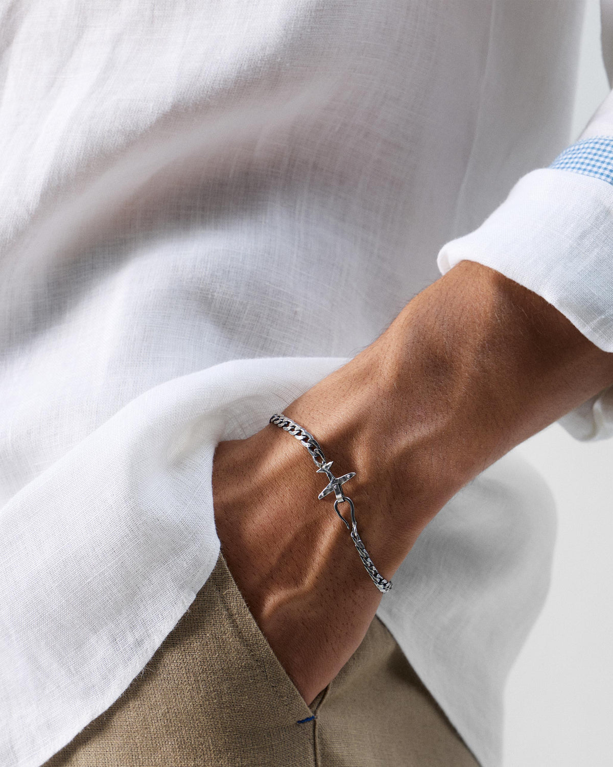 Person wearing a silver flight bracelet with airplane clasp.