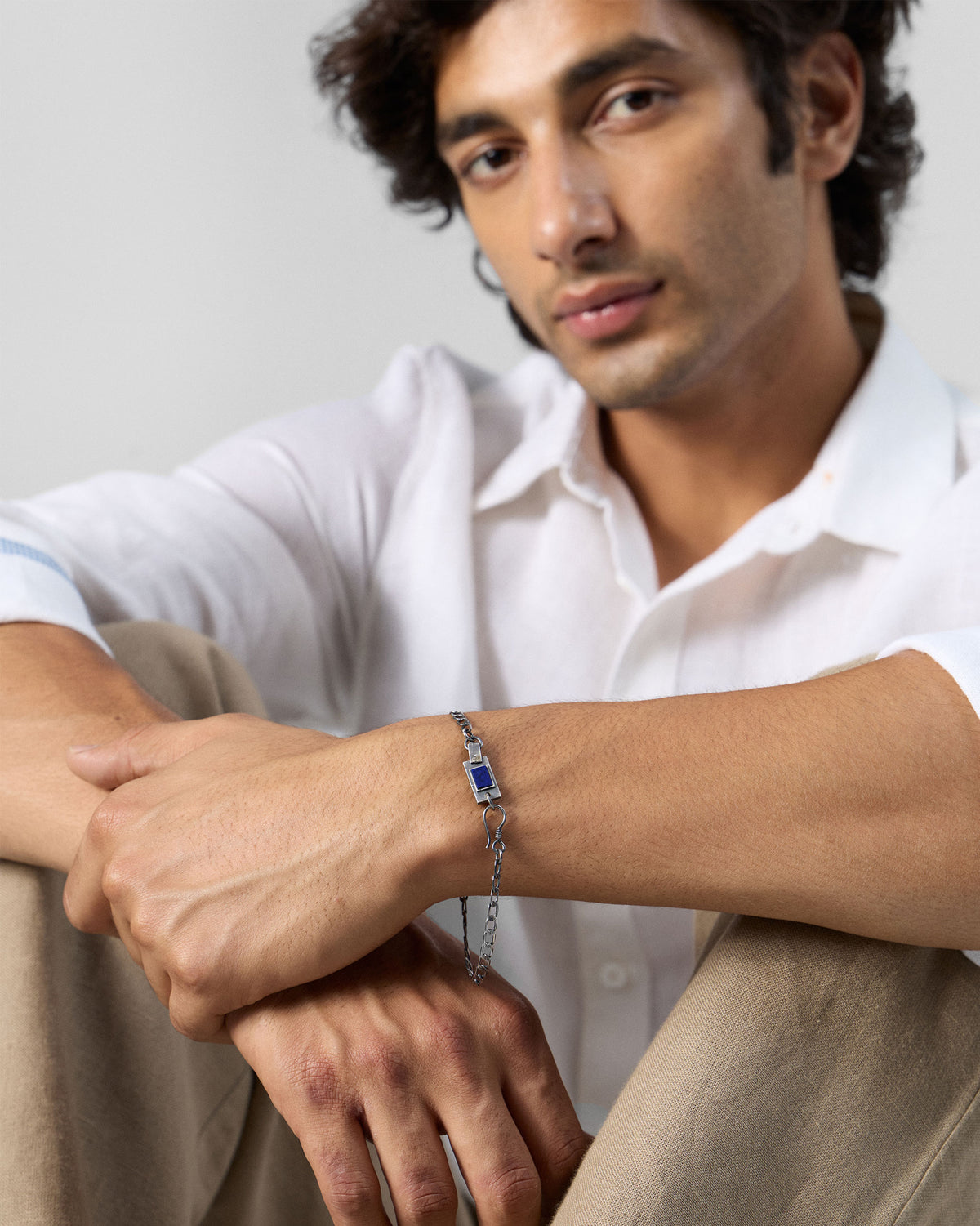 Person wearing a silver Taro bracelet with a blue stone plaque.