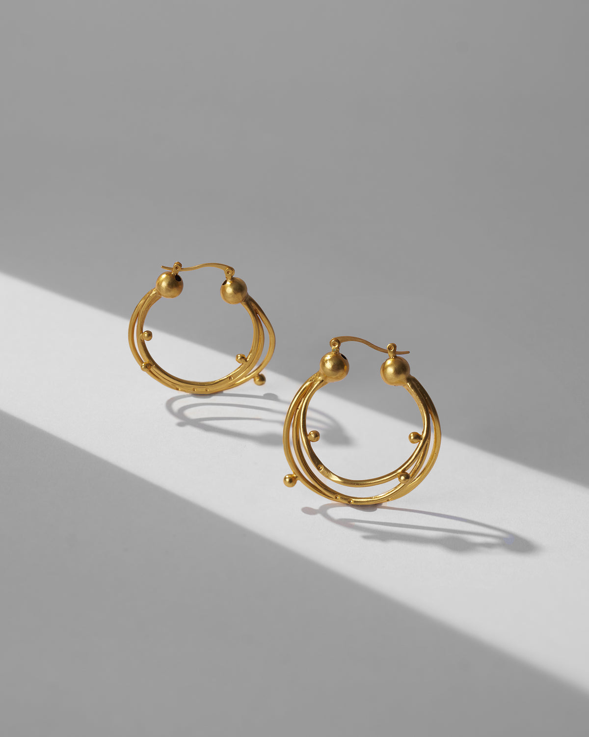 Pair of gold Celestial balis showing layered orbital hoops and latch backs.