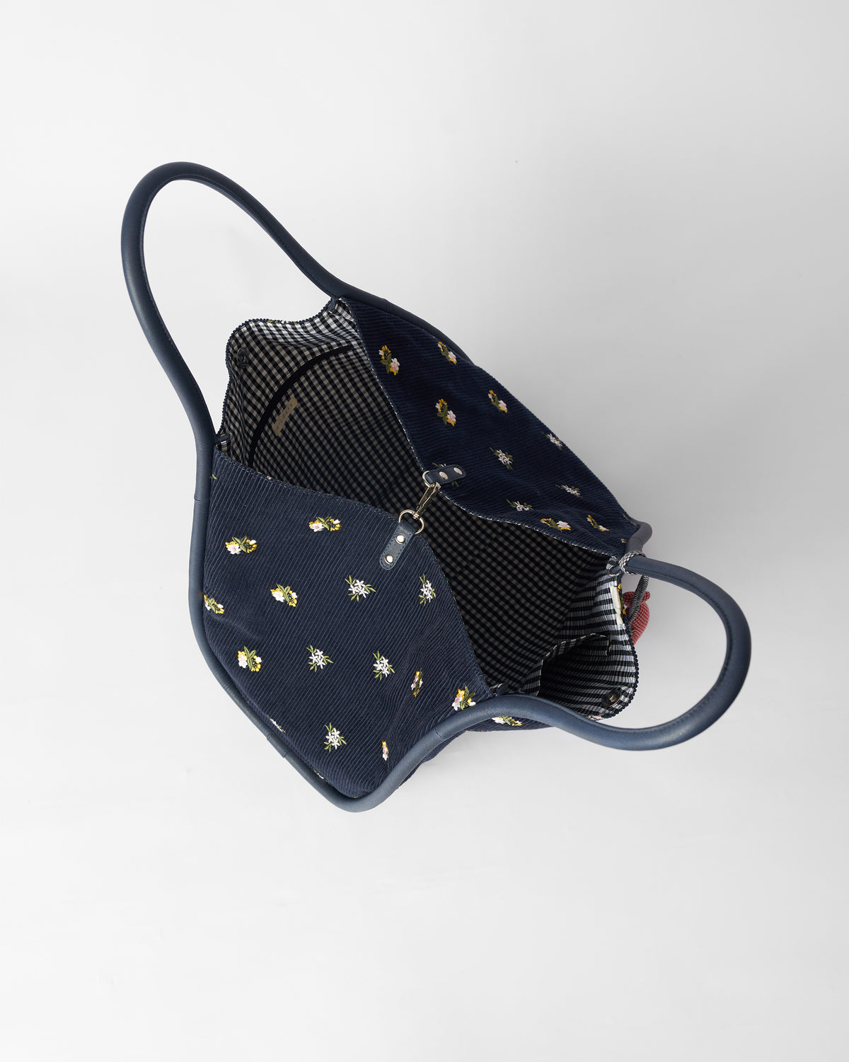 Open navy Ditsy bag showing a black and white gingham lining.