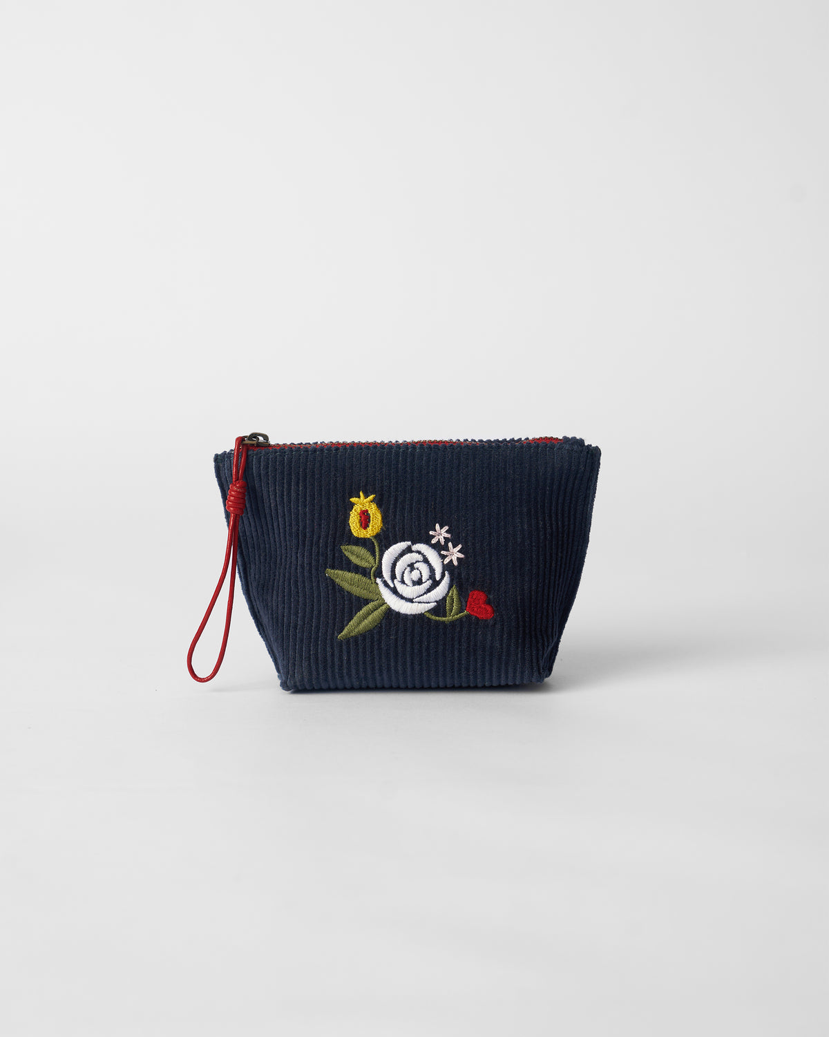 Navy Ditsy coin pouch with white rose embroidery and a red zipper.