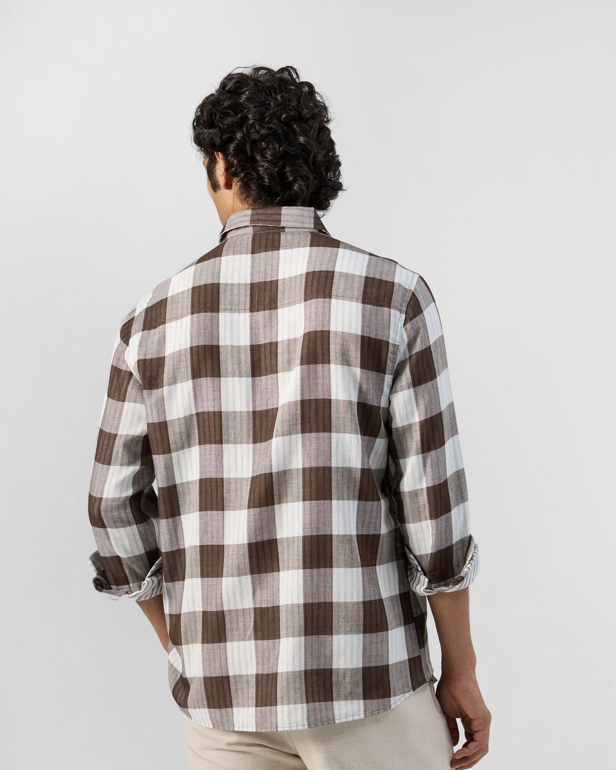 Back of a brown and white check Milaan shirt worn by a person.