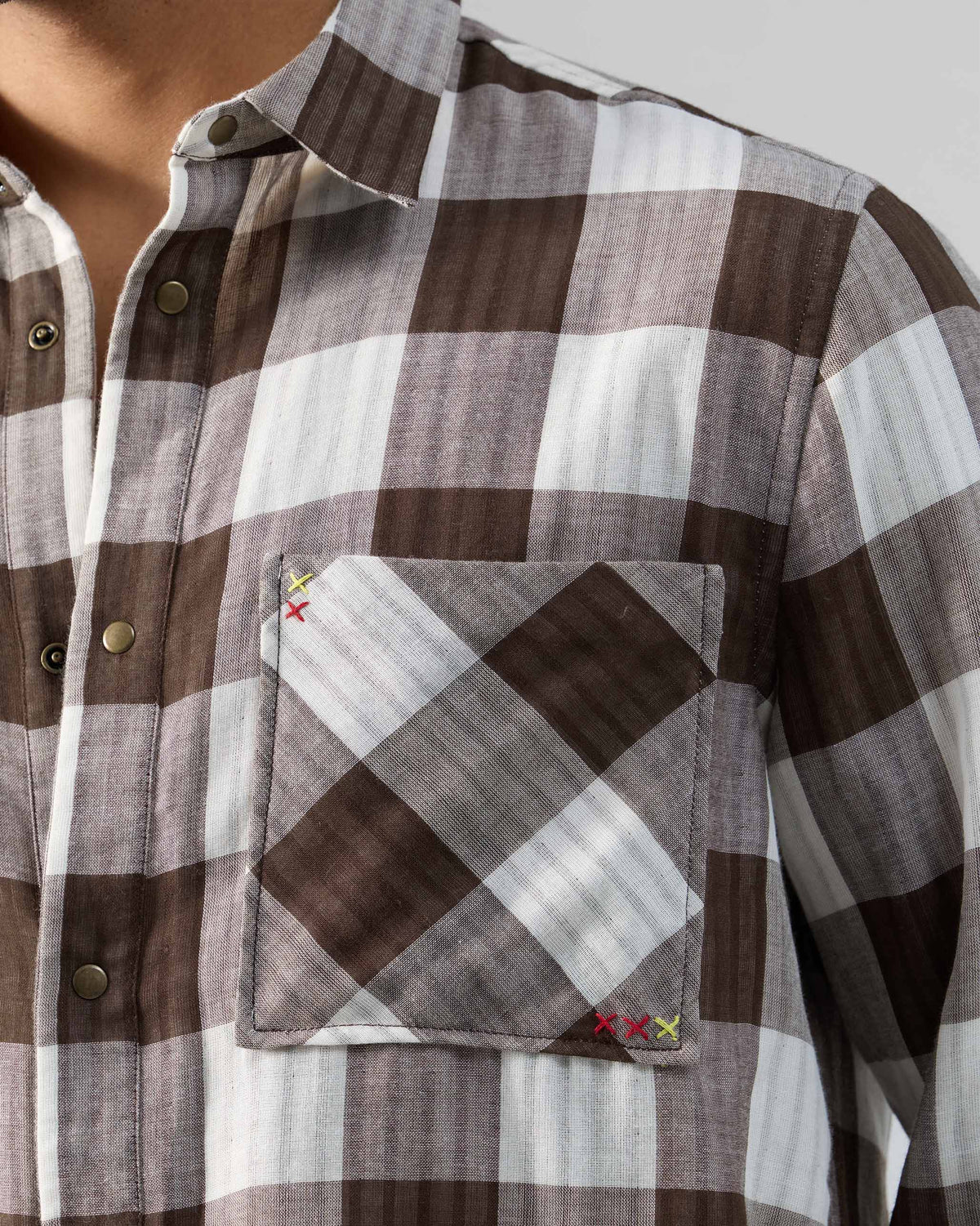 Close-up of a Milaan shirt pocket with cross-stitch details.