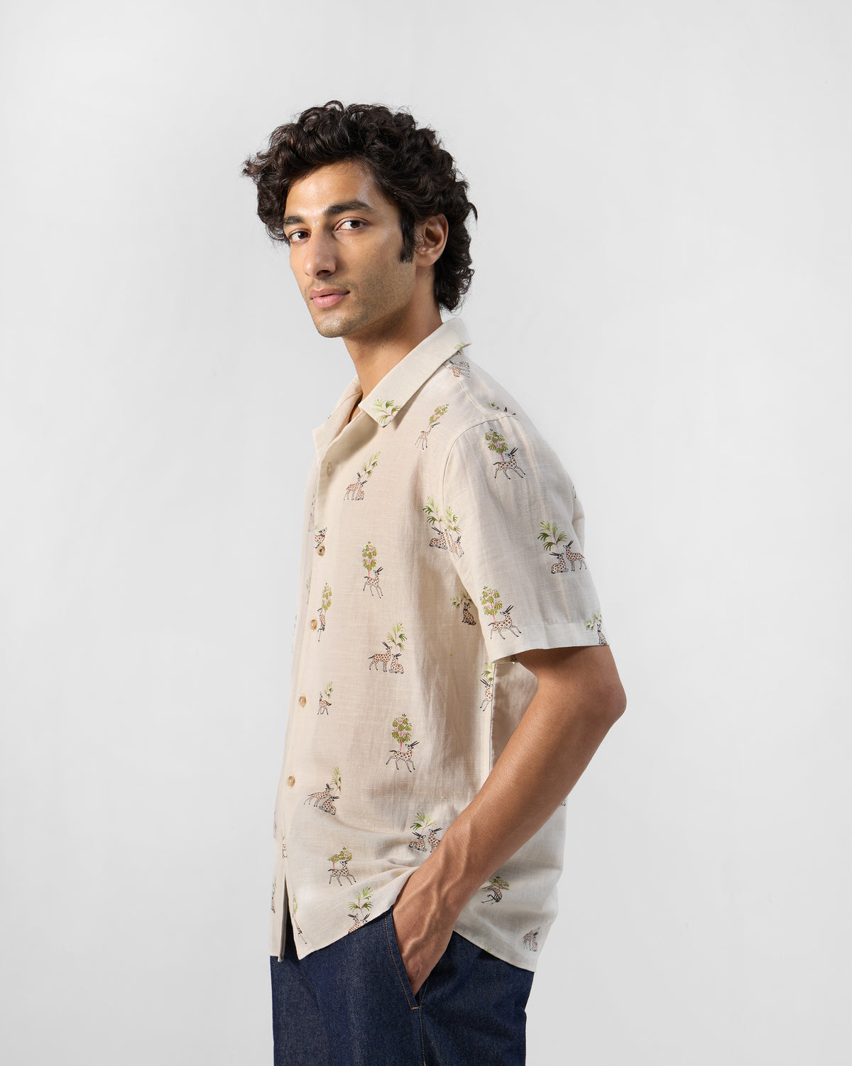 Side view of a cream Bena shirt with a deer and tree print.