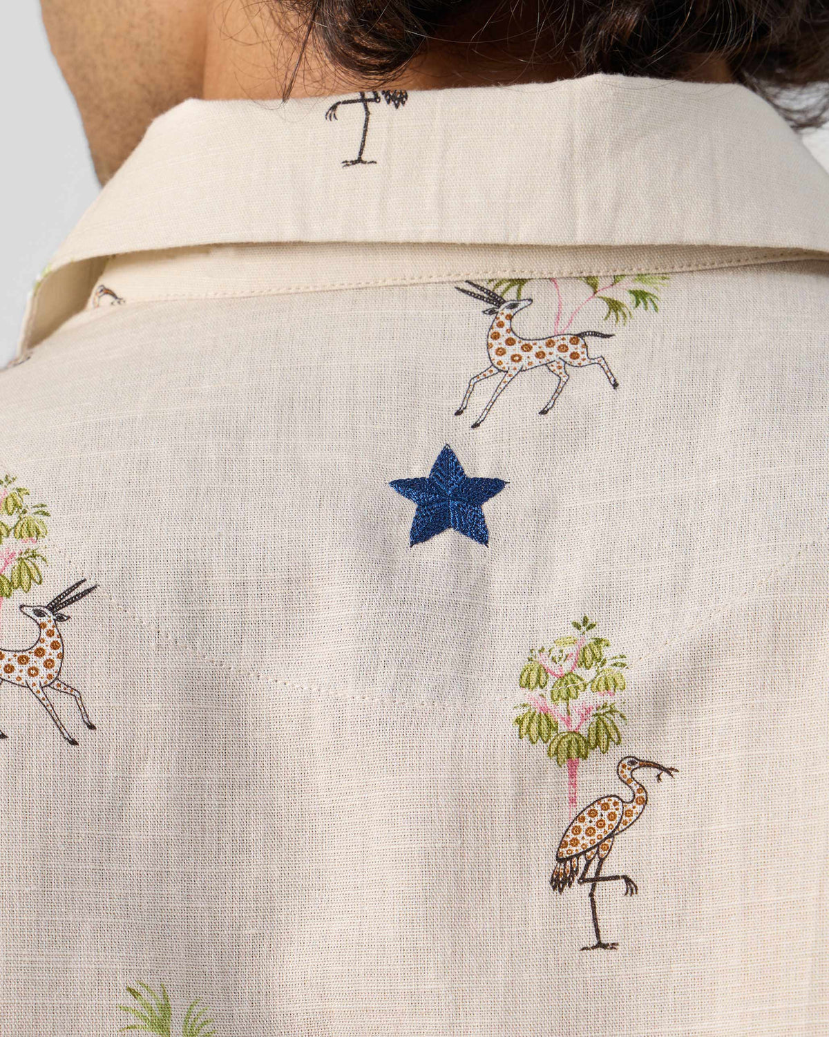 Close-up of the Bena shirt back showing a blue star embroidery.