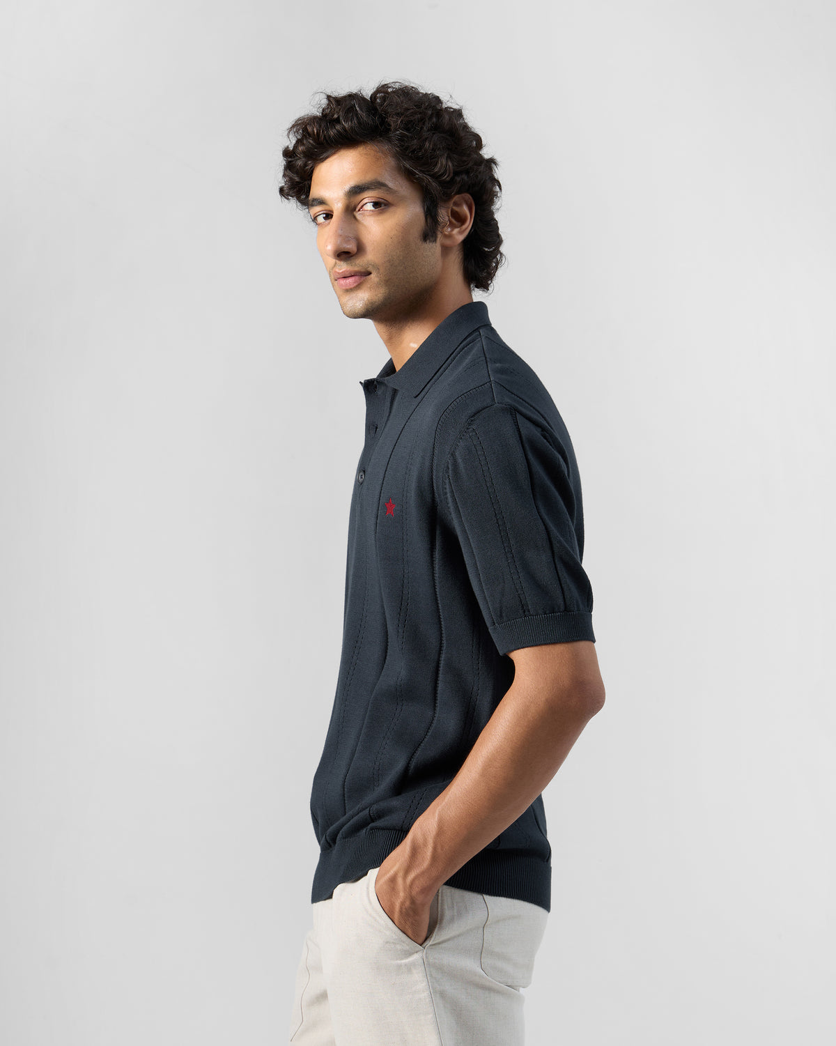 Side view of a dark navy Midnight polo with a vertical ribbed knit.