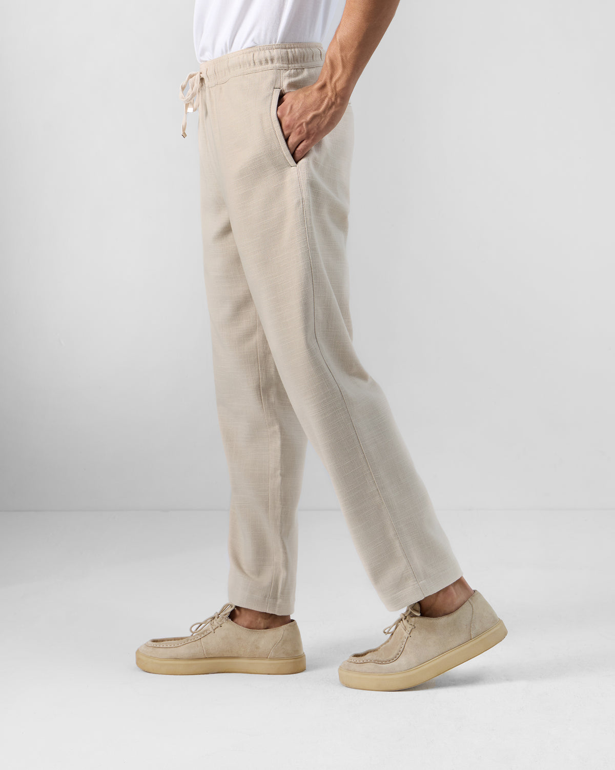 Side view of beige Breeze trousers with a relaxed straight leg.