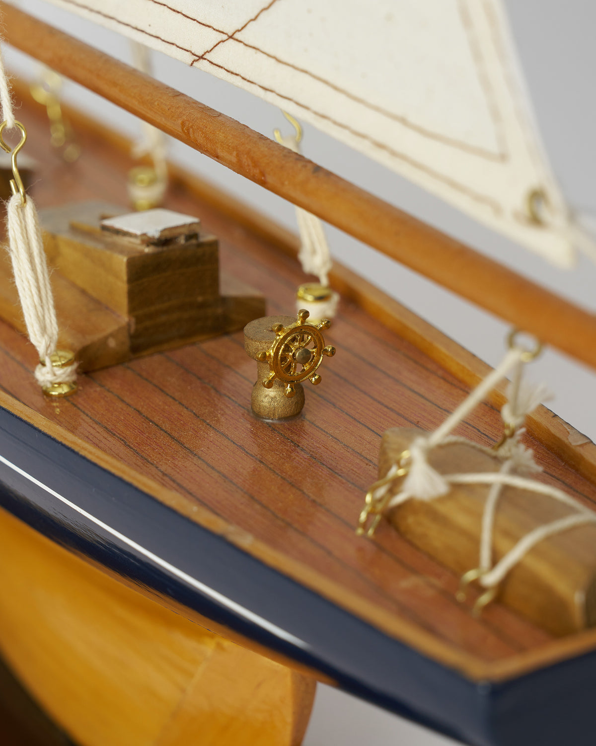 Close-up of the Sail Boat Home Accent deck with a brass ship's wheel.
