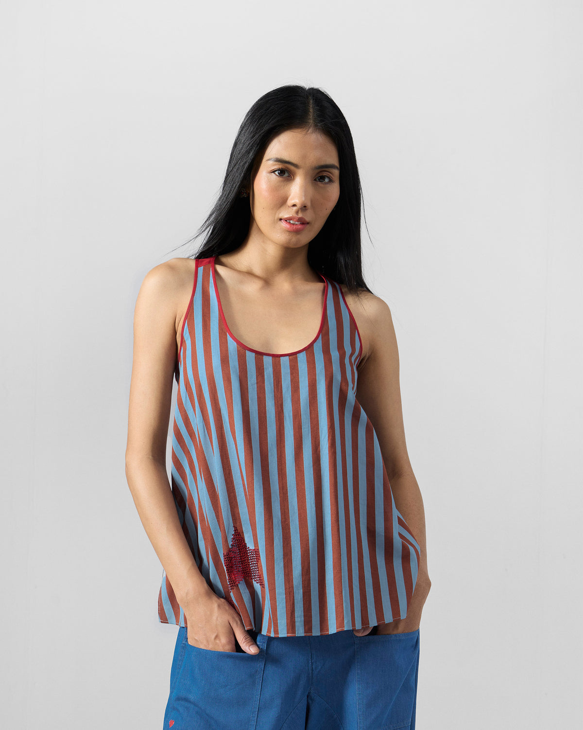 Person wearing a blue and brown striped Ukiyo racerback top with a red star.