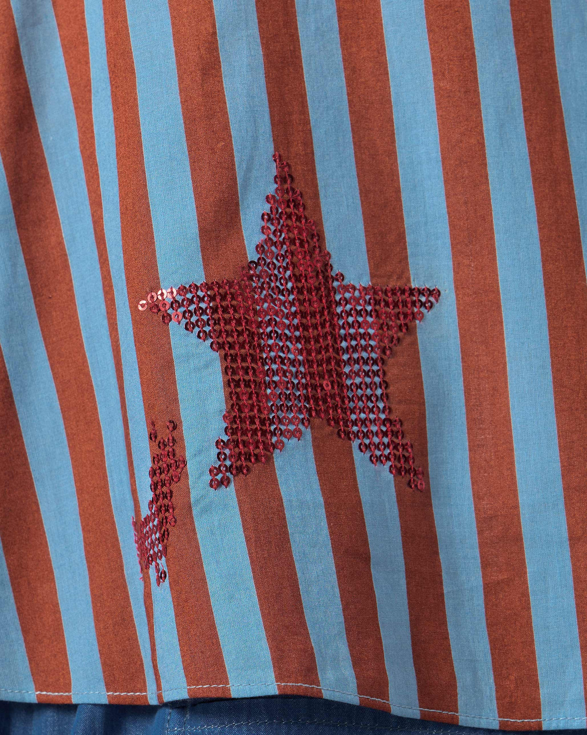 Close-up of an Ukiyo racerback top showing a red sequin star.