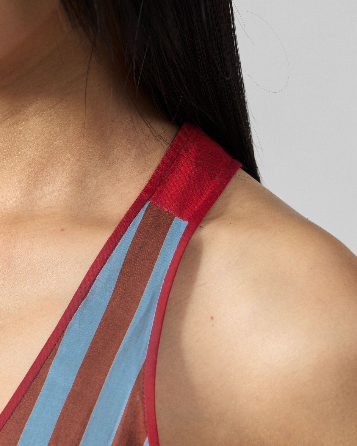 Close-up of an Ukiyo racerback top showing red straps and piping.