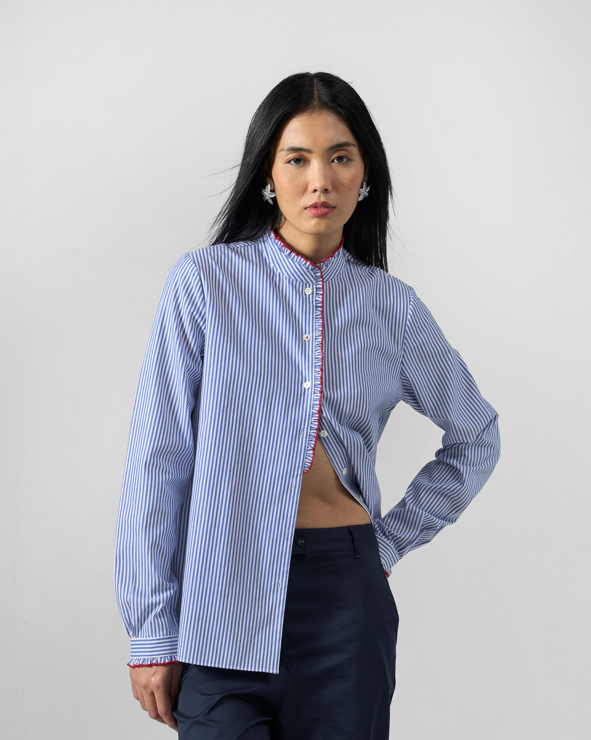 Person wearing a blue and white striped Sora ruffle shirt.