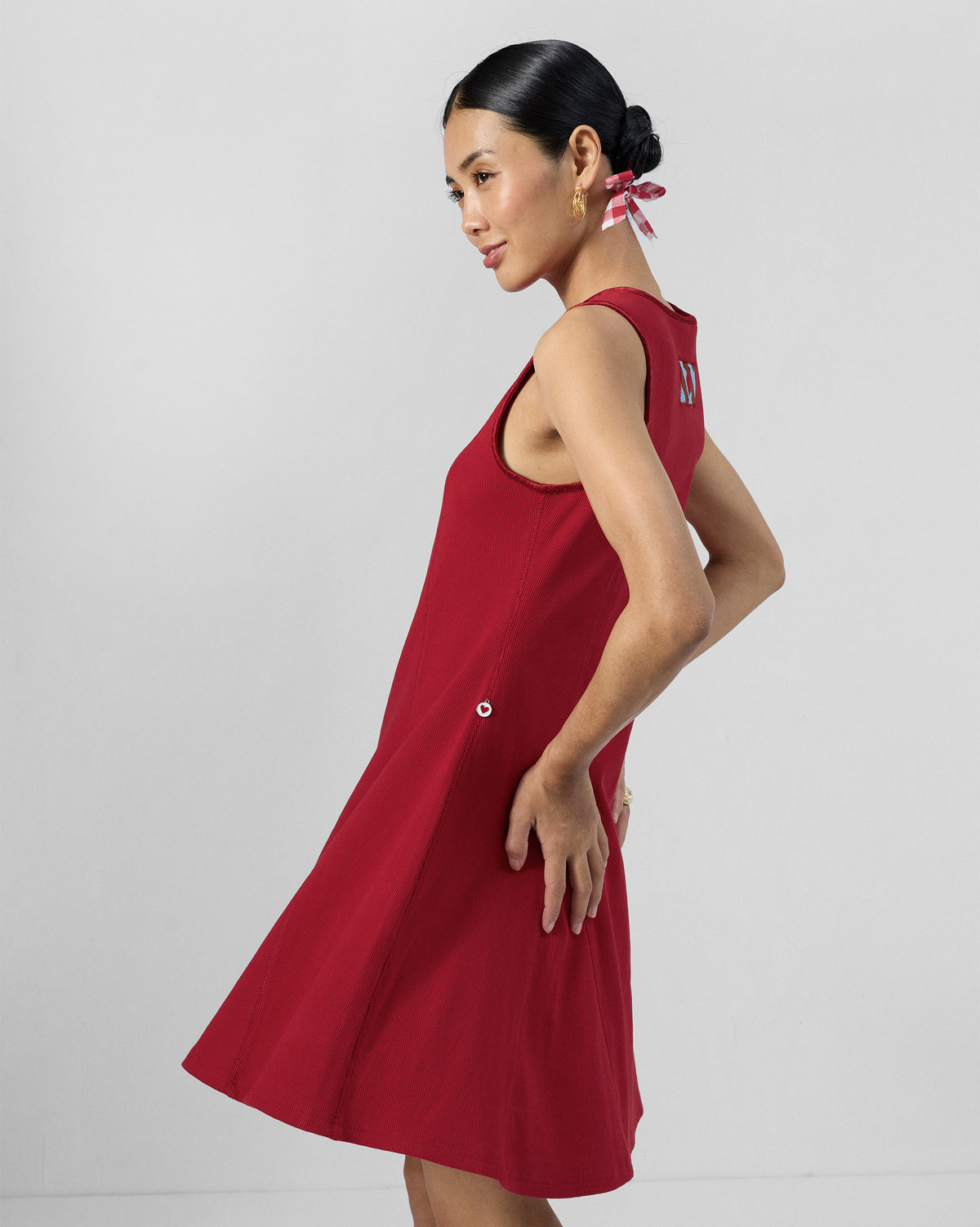 Side view of a red Norva skater dress worn by a person.