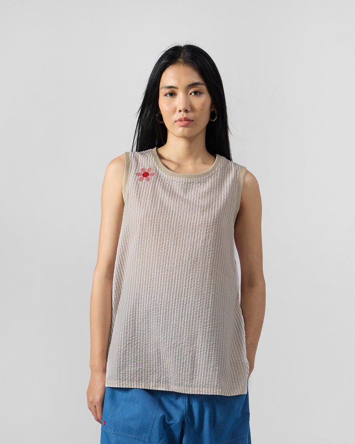Person wearing a brown and ivory striped seersucker top with a flower appliqué.