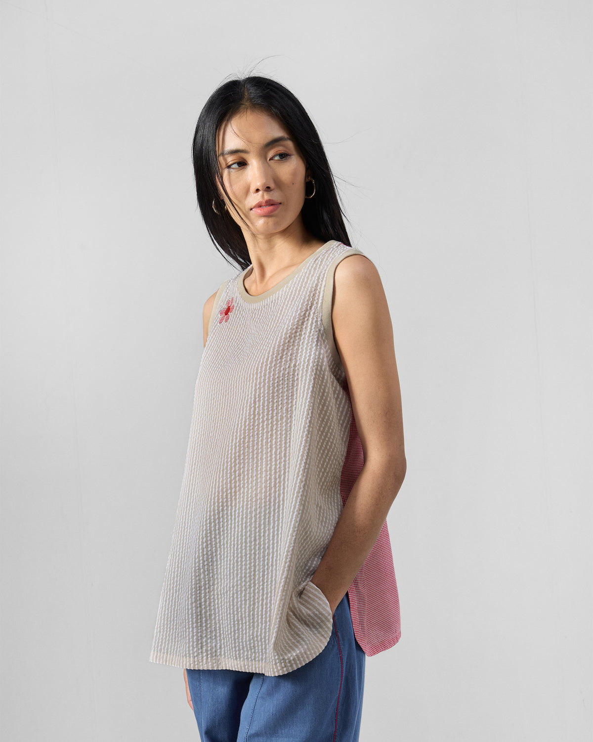 Three-quarter view of a brown and ivory striped top with a pink back.