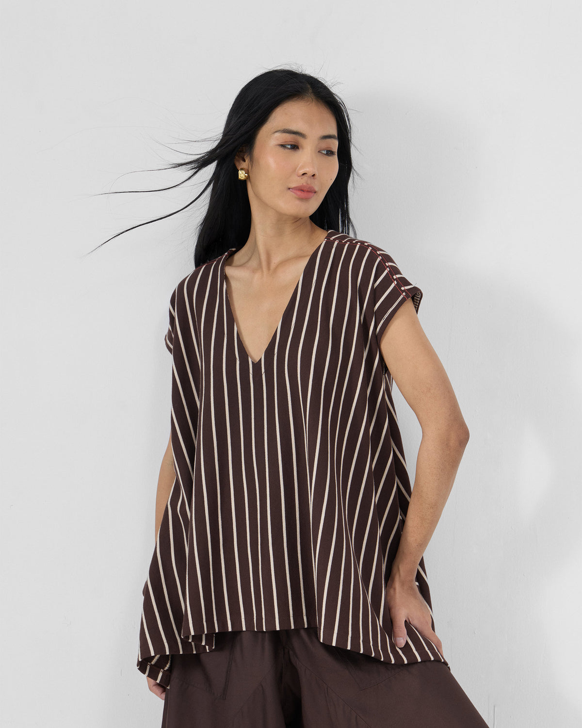 Person wearing a brown and ivory striped Nera kaftan top.
