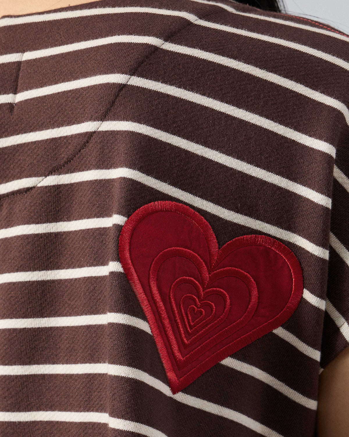 Close-up of a red heart on a brown and ivory striped Nera kaftan top.