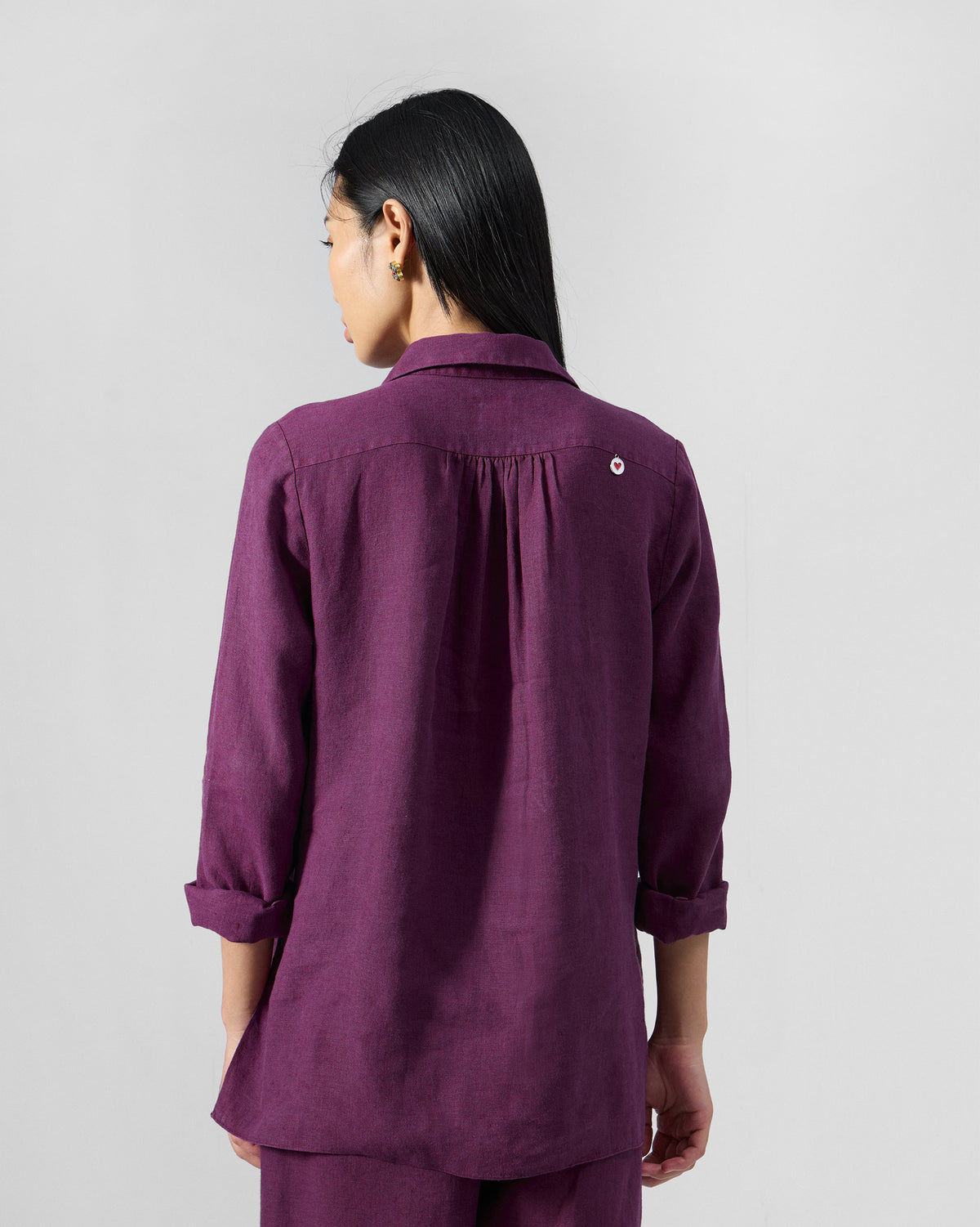 Back of a plum Mati linen shirt with a gathered yoke.