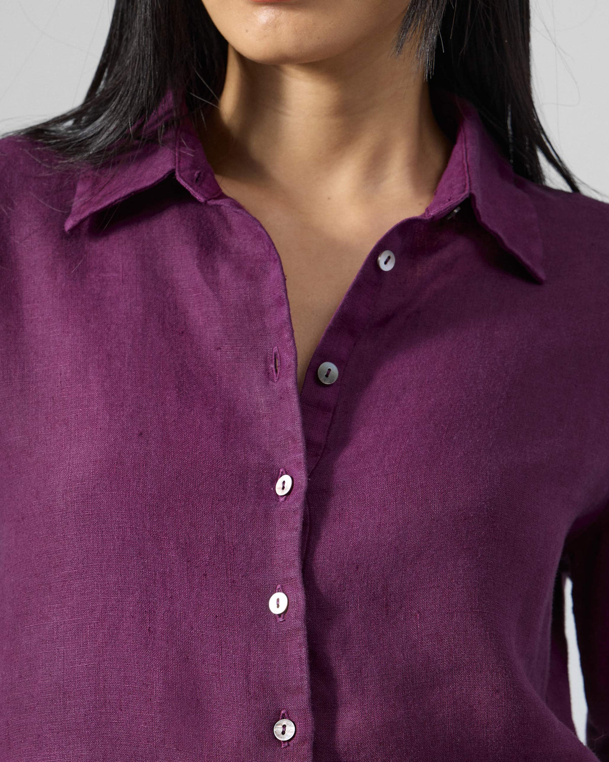 Close-up of the collar and button placket on a plum Mati linen shirt.