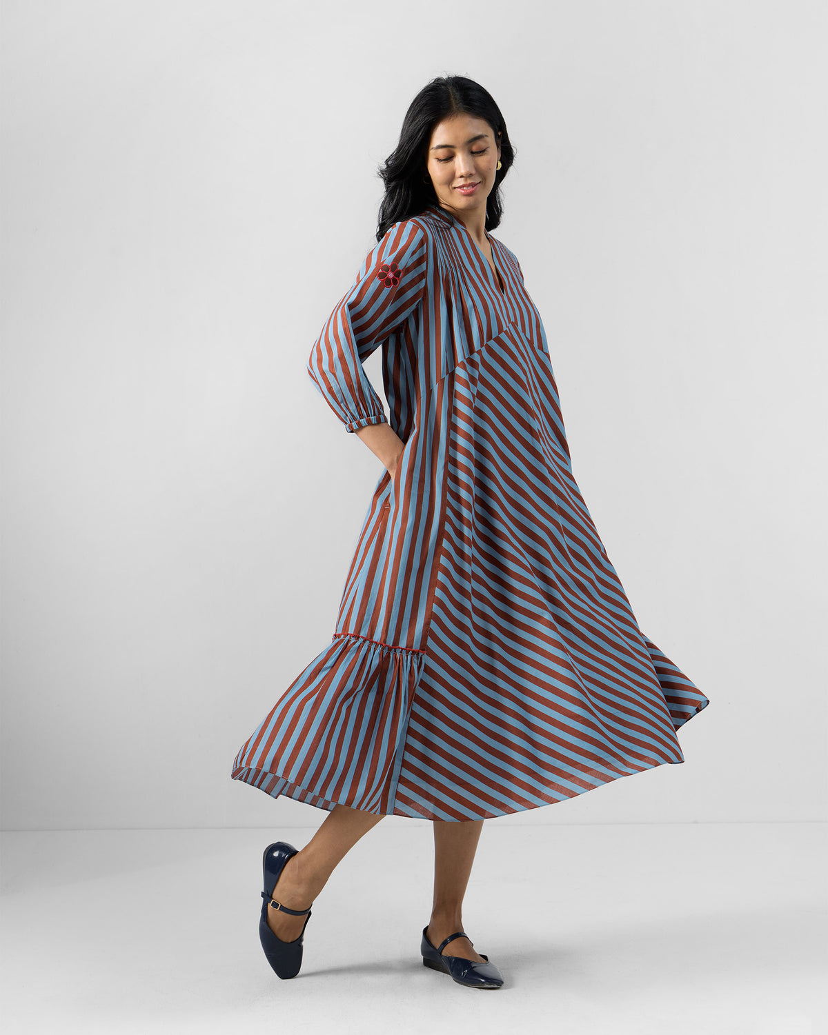 Person wearing a blue and brown striped Summer Tea dress with a flared skirt.