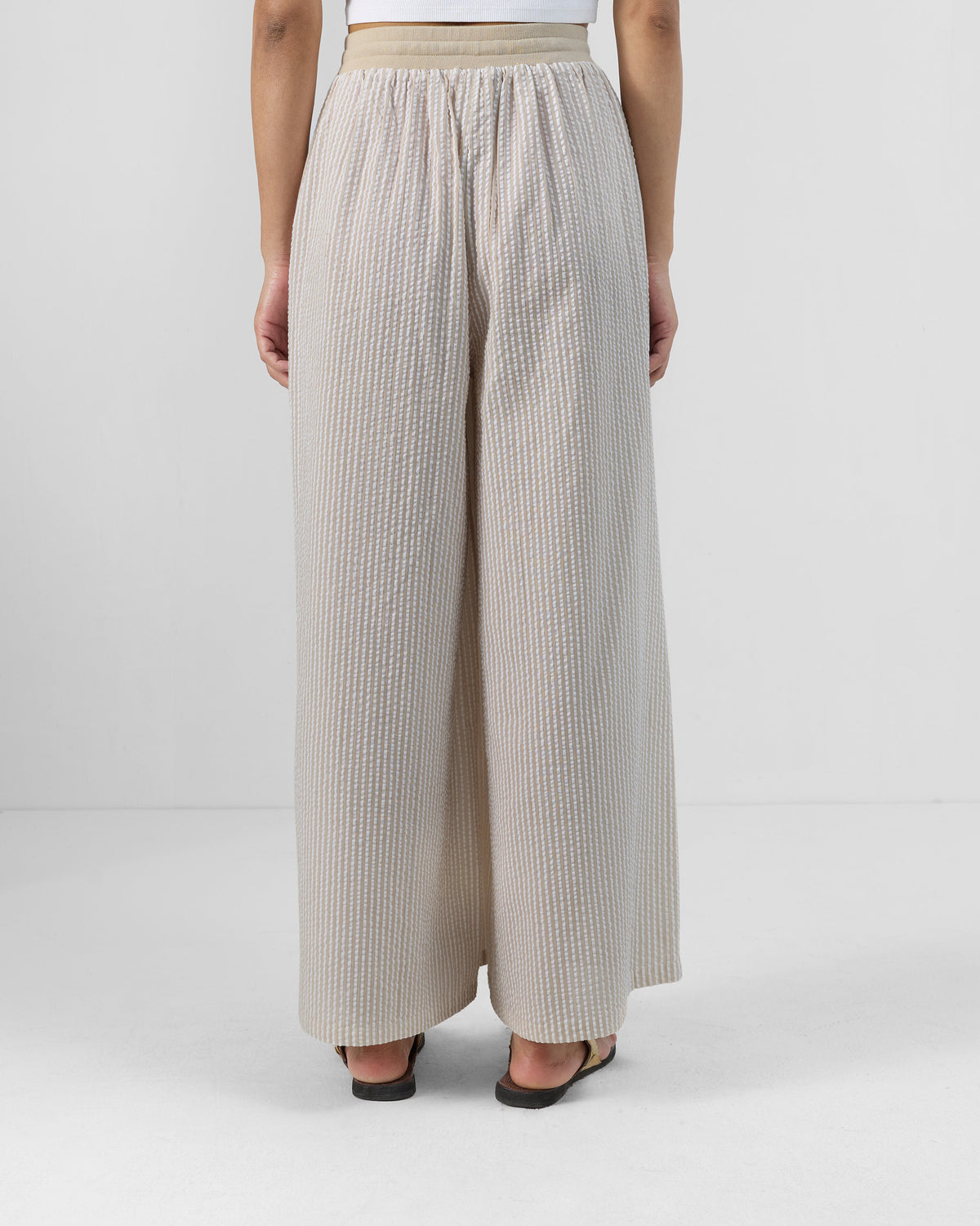 Back of brown and ivory striped Hera Pants with a flared silhouette.