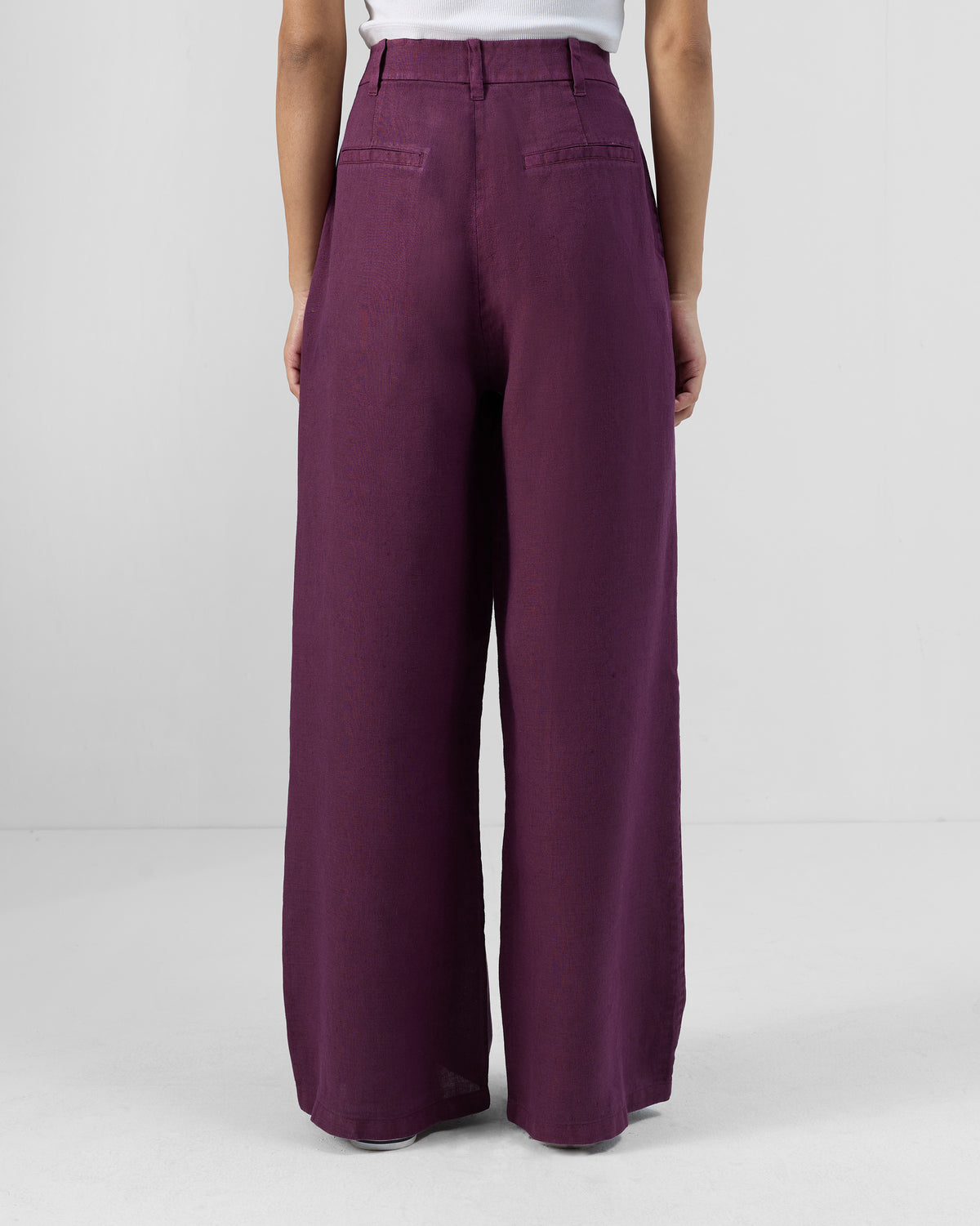 Back of plum linen Aven pants with twin welt pockets.