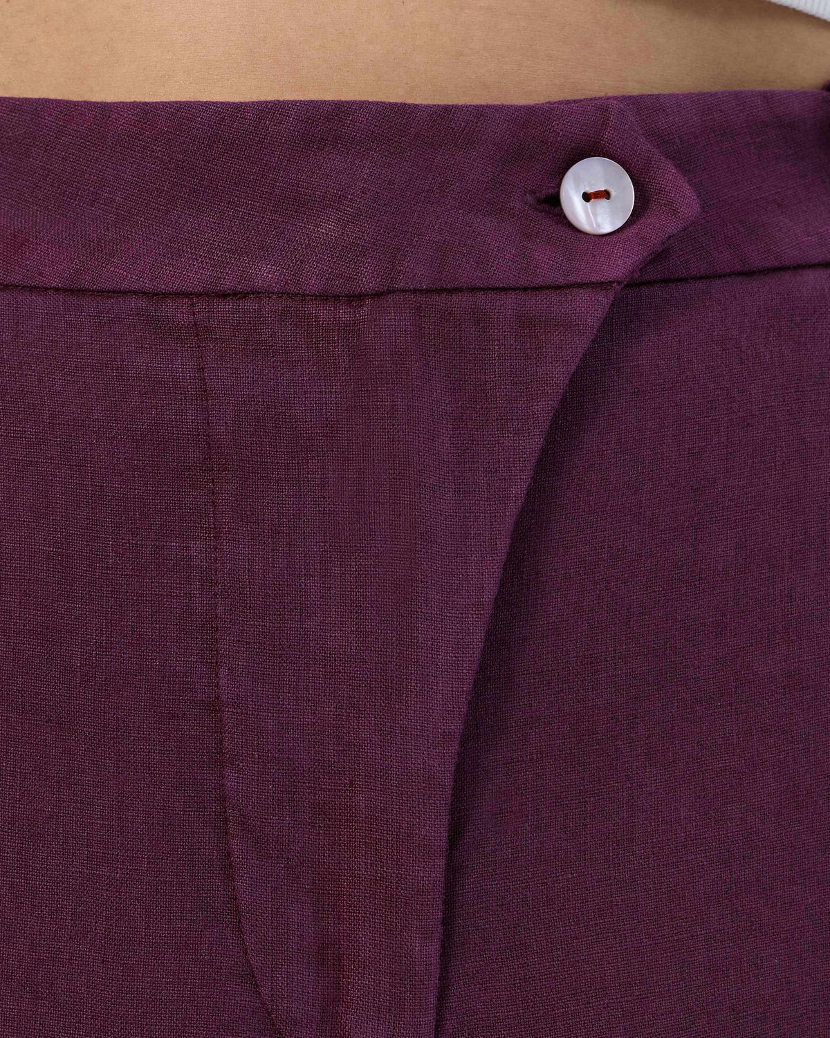 Close-up of plum linen Aven pants showing the white waist button.