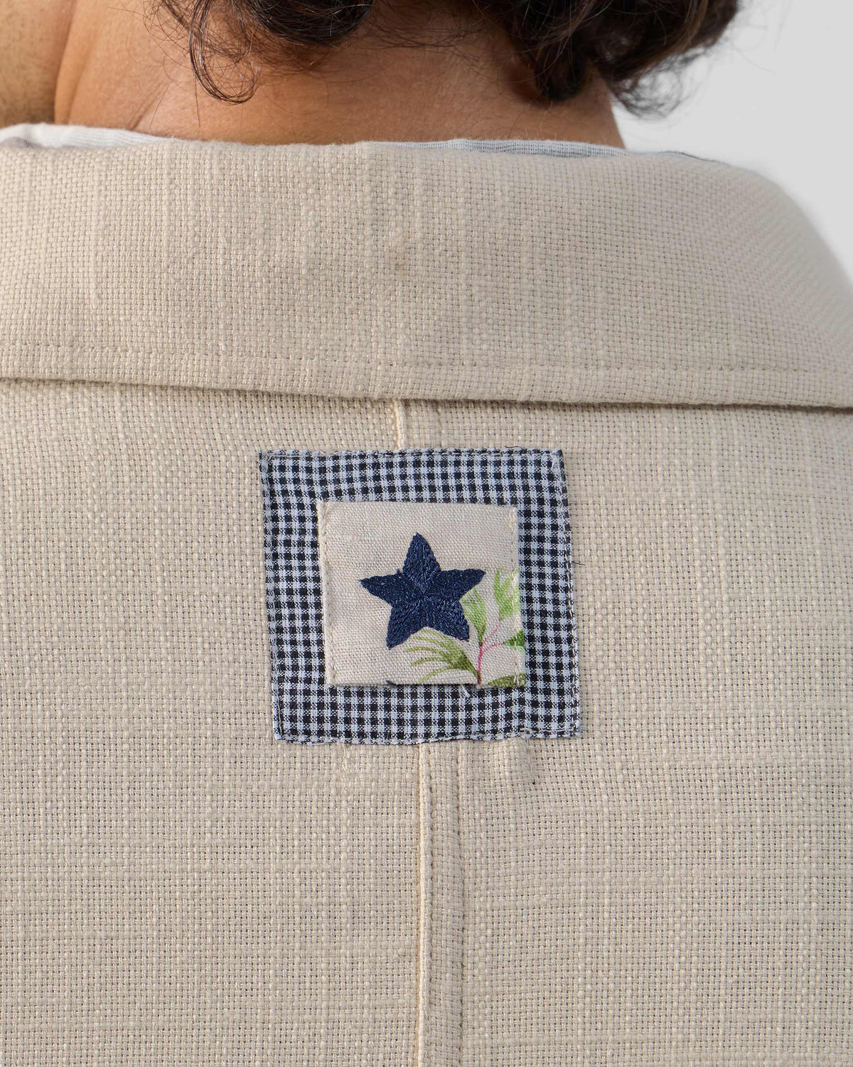 Close-up of a navy star patch on the back of a light beige Dune shacket.